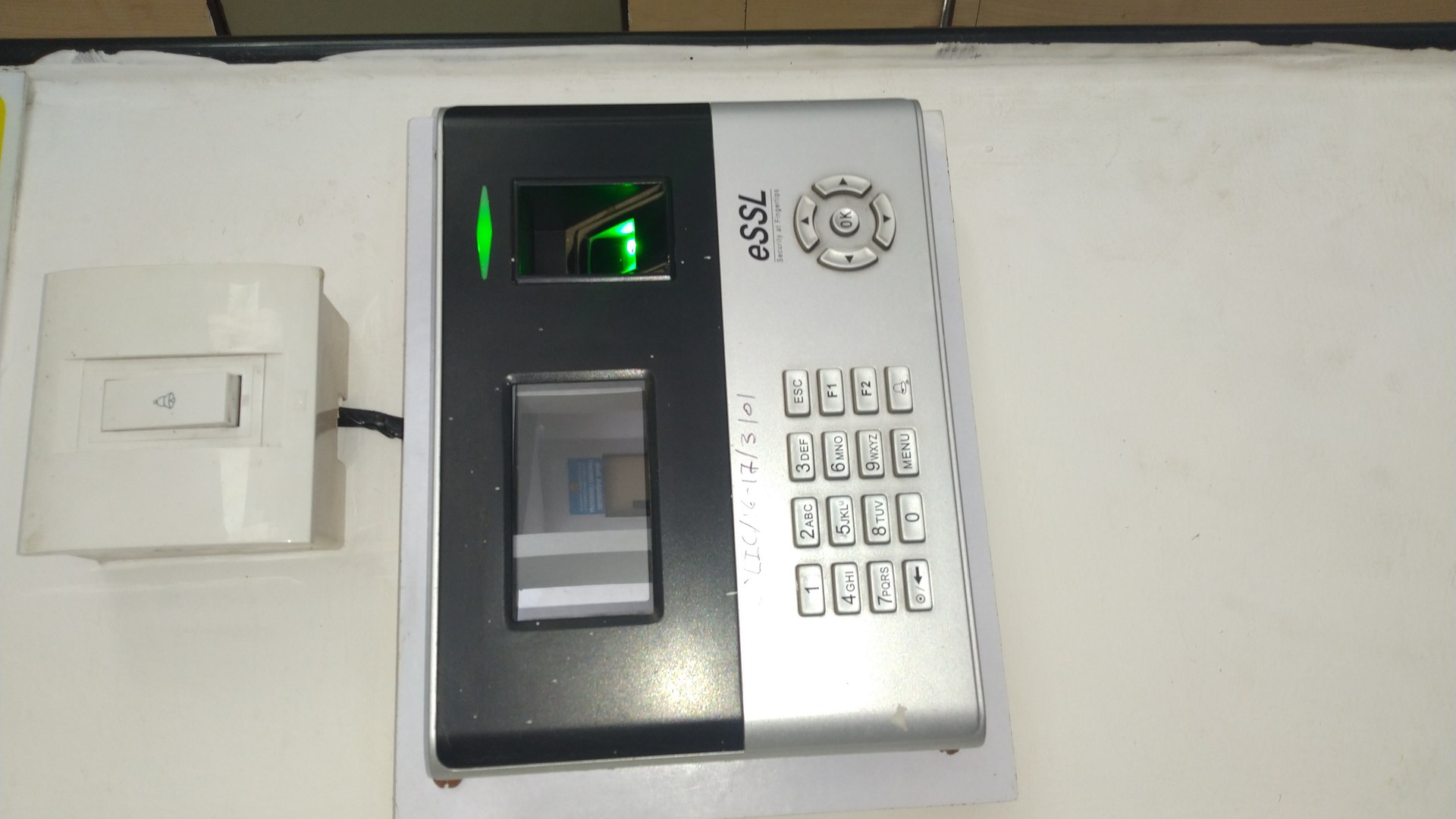 A wall-mounted biometric fingerprint identity scanner — the physical "prove who you are before you get in" device at the centre of enterprise access control. It stands in for the shift the piece describes: AI agents, like employees, now need their own verifiable identities before they can act inside the enterprise. Photo: Sanskritibharti1398 / Wikimedia Commons, CC BY-SA 4.0