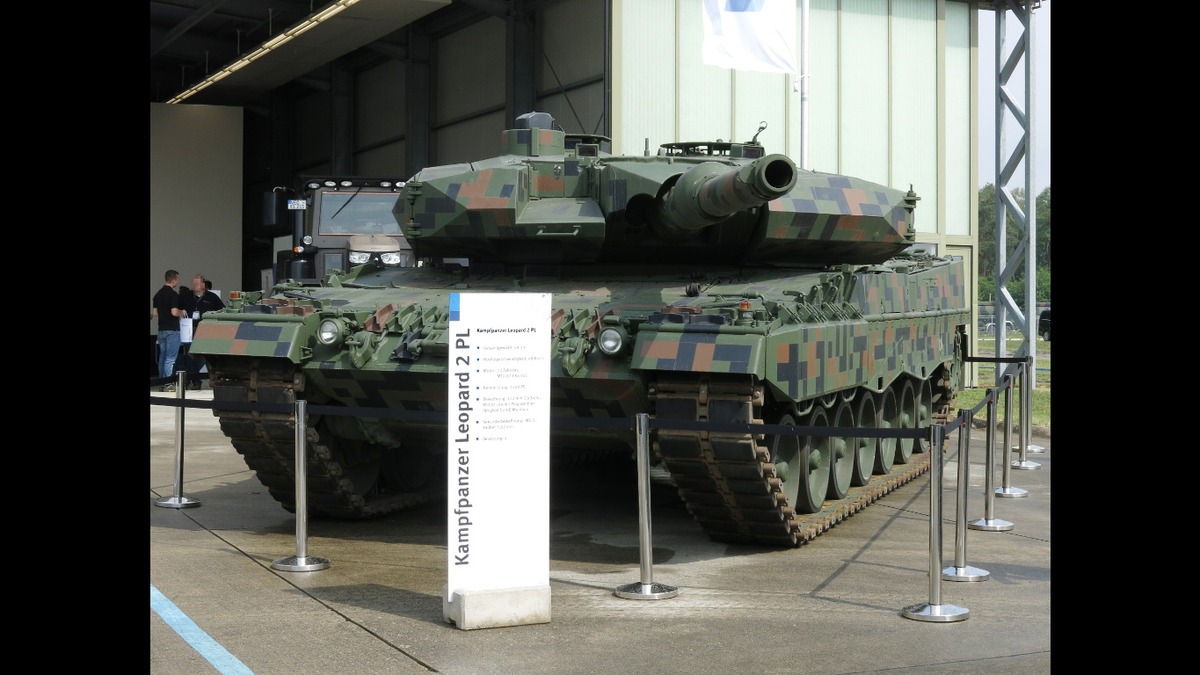 A Polish Leopard 2 PL main battle tank in digital camouflage — Rheinmetall supplies the 120mm smoothbore gun that arms Leopard 2 fleets across NATO, making it the backbone of European armor.